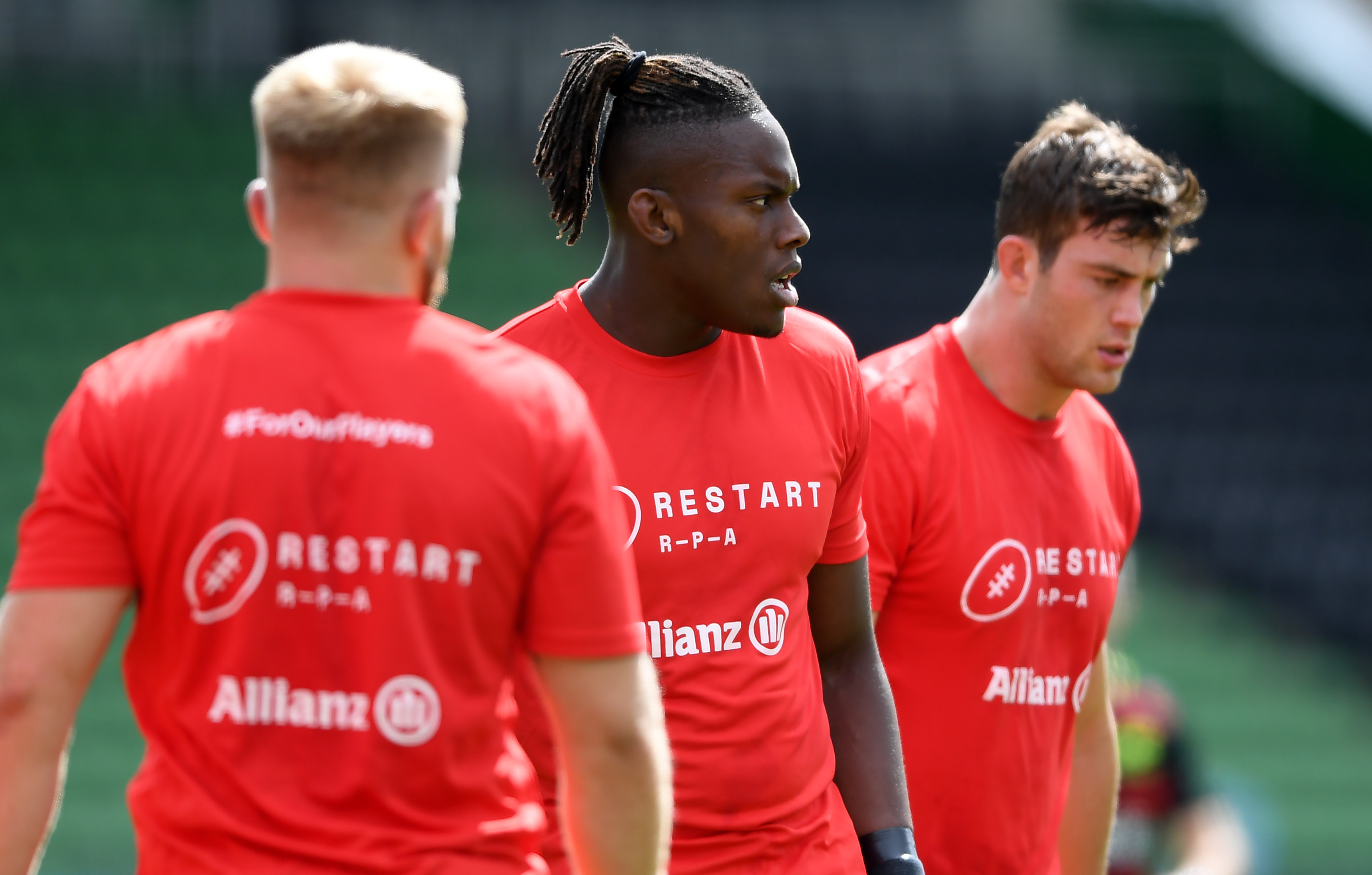 Three people playing Rugby