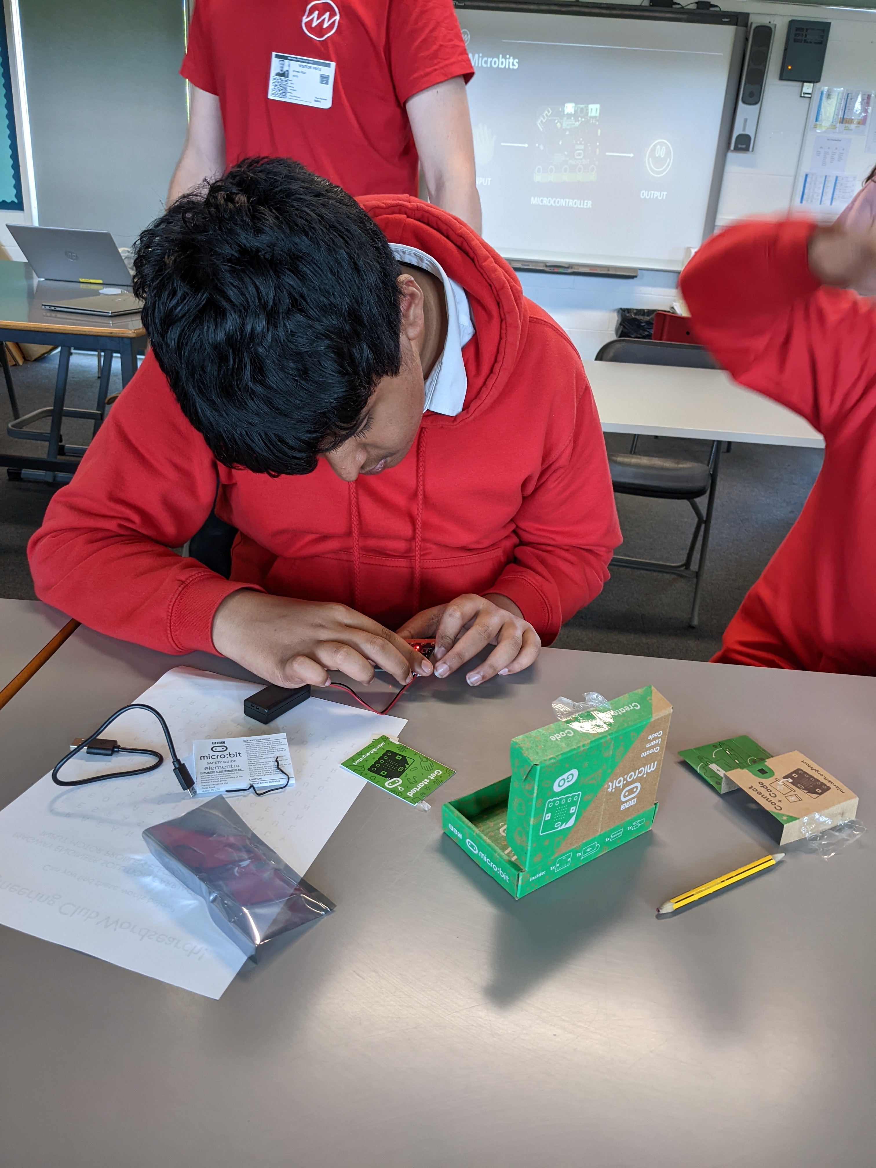Boy at a desk investigating an electrical device