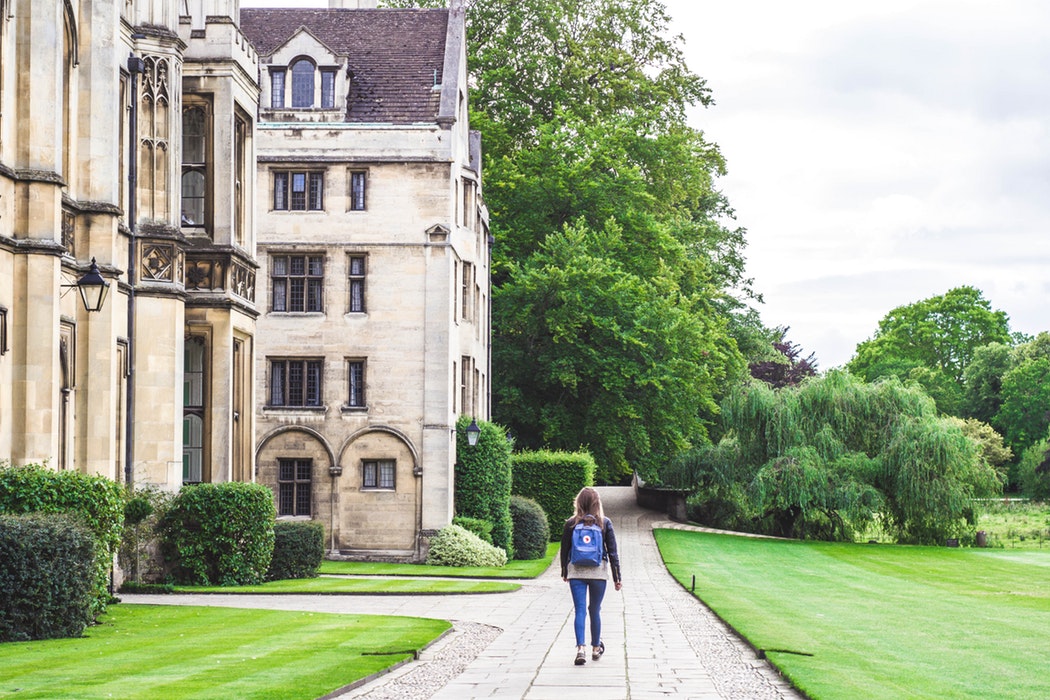 Girl walking by a stately home